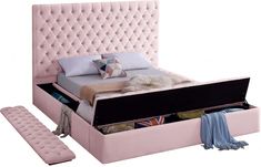 a pink bed with an ottoman underneath it and pillows on the bottom shelf next to it