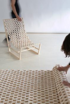 two people are standing near a chair made out of woven material