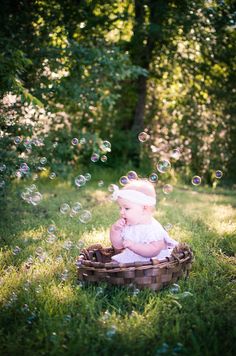 a baby sitting in a basket with soap bubbles