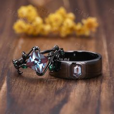 a ring with an unusual design on it sitting on a wooden table next to some yellow flowers