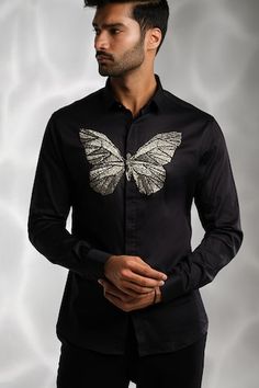 Black cotton shirt with silver cutdana hand embroidered butterfly.
Components: 1
Pattern: Hand embroidered
Type Of Work: Cutdana
Neckline: Collar
Sleeve Type: Full
Fabric: Cotton
Color: Black
Other Details: 
Note : Pant worn by the model is not for sale.
Occasion: Party - Aza Fashions Hand Embroidered Butterfly, Men Shirts Casual, Butterfly Shirt, Butterfly Shirts, Embroidered Butterfly, Shirts Black, Men Shirts, Not For Sale, Embroidered Shirt