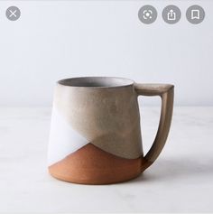 a white and brown mug sitting on top of a table