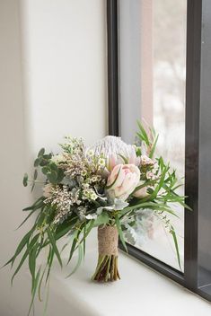 a bouquet of flowers sitting on top of a window sill