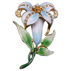 Discover the allure of vintage fashion with this enchanting vintage Coro flower pin brooch. With its classic floral design, this brooch is a testament to timeless style and sophistication. The intricate petals are beautifully crafted with white, and blue enamel providing a splash of contrast against the green stem and petals. Sparkling crystals nestled at the center of the flower add a hint of glamour, while the gold-tone setting offers a classic finish that never goes out of style! Unsigned Cor Green Blue Crystals, Coro Jewelry, Moda Vintage, Flower Pins, Fantasy Jewelry, Gorgeous Jewelry, Sparkling Crystal, Mode Vintage, Design Floral