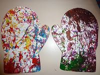 two paper mitts with paint splattered on them