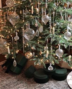 a christmas tree with ornaments hanging from it's branches and green velvet shoes underneath