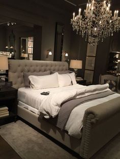 a bedroom with a large bed and chandelier