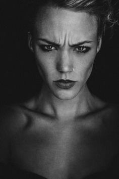 a black and white photo of a woman's face with her nose piercings