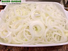 a white dish filled with onions on top of a counter