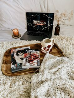 a tray with magazines and a coffee cup on it next to an open laptop computer