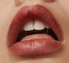 a woman's lips are shown with the tip of her tongue sticking out from under it