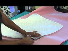 a woman is cutting fabric with scissors