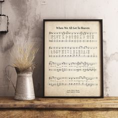 an old sheet music score is displayed next to a vase with dried grass in it