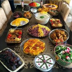 a table filled with lots of different types of food on top of plates and bowls