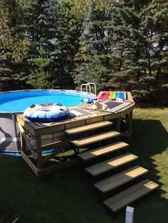 an above ground swimming pool with steps leading up to it and a life preserver in the background