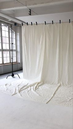 an empty room with a white curtain hanging from the ceiling