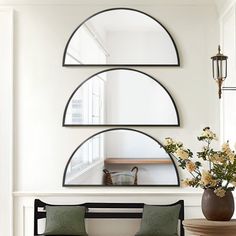 a living room filled with furniture next to a mirror and vase on top of a table