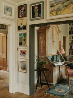 a living room filled with furniture and pictures on the wall above it's doorway