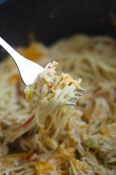 a fork full of noodles with chicken and cheese