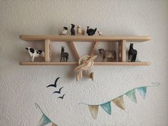 wooden shelves with toy animals on them and bunting flags hanging from the wall behind them