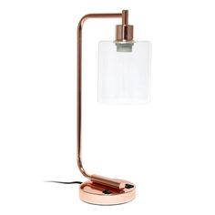 a table lamp with a glass block on the base and a copper colored metal arm