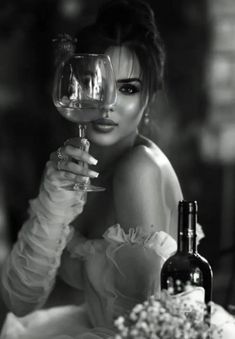 black and white photograph of a woman holding a wine glass in front of her face