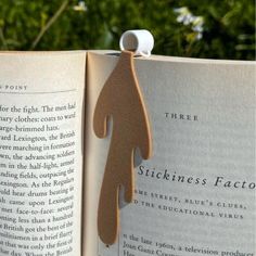 an open book with a wooden cutout of a person