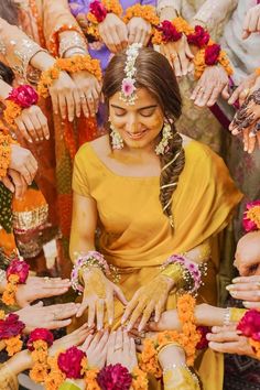 a group of people standing around each other with their hands in the air and flowers all around them