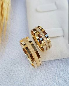 two gold rings sitting on top of a white towel next to a wheat earring