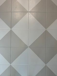 a white and gray tiled wall in a bathroom