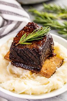 a white plate topped with mashed potatoes and meat