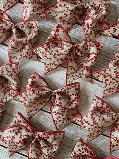 several red and white bows sitting on top of a wooden table next to each other