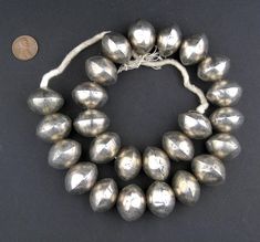 This beautiful strand of silver saucer-shaped beads was made in Mali West Africa. Beads such these are said to be made by melting old silver coins or brass bracelets and reusing the material. In recent years, these beads are becoming more difficult to find as many of the traditional artisans leave the villages in pursuit of new opportunities. These hollow Mali beads are light-weight and fun to use. Great as accents or to add character to your unique jewelry designs. Each bead measures approximately 18-20 x 25-27mm diameter with about 25 beads per strand. Individual beads may show some wear such as small nicks due to age. Old Silver Coins, Brass Bracelet, Unique Jewelry Designs, Yemen, Creative Jewelry, Beading Supplies, West Africa, Beads Jewelry, Silver Coins