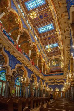 the interior of a large church with stained glass windows and chandeliers hanging from the ceiling