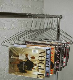 a magazine rack holding magazines on top of a white brick wall