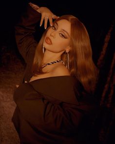 a woman with long brown hair posing for the camera