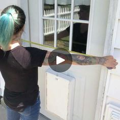 a woman with blue hair is measuring out the door