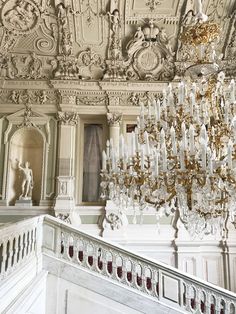 an ornate chandelier hangs from the ceiling in a room with white walls and ceilings