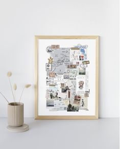 a white vase sitting next to a wall with pictures on it and a plant in the corner