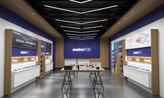 the interior of an electronics store with many tables and stools in front of them