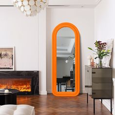 an orange mirror in the middle of a living room with a fire place and fireplace