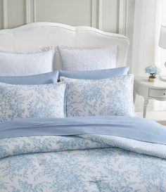 a bed with blue and white comforters in a bedroom