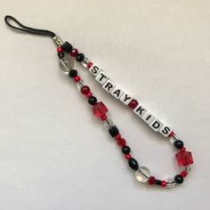 a red and black beaded lanyard with the word staykids on it