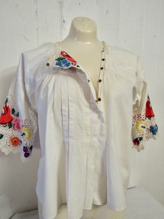 "Vintage 1950s (maybe earlier) white cotton shirt or peasant blouse. Has lace and embroidered half sleeves and a snap front. Hippy flower child style. Size medium/large, or one size fits all. Actual measurements are: 43\" at the bust 54\" at the waist 22\" overall length In very good condition." Bohemian Spring Shirt For Daywear, Spring Bohemian Shirt For Daywear, Bohemian Shirt For Spring Daywear, Bohemian Spring Daywear Shirt, White Boho Collar Blouse For Spring, White Spring Blouse With Boho Collar, White Blouse With Boho Collar For Spring, Spring Short Sleeve Blouse With Boho Collar, Traditional Summer Blouse With Buttons