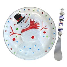 a glass plate with a snowman on it next to a spoon