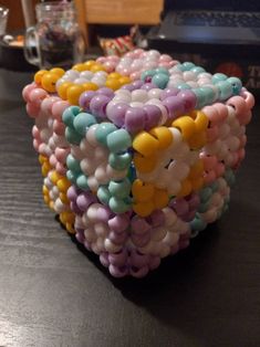 a bunch of balloons that are on top of a table in the shape of a cube