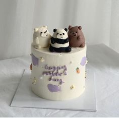 a birthday cake decorated with three bears and pandas on it's top tier