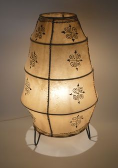 a lamp that is sitting on top of a white surface with an intricately designed design