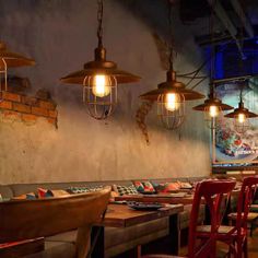 a restaurant with tables and chairs, lights hanging from the ceiling