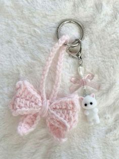 a crocheted keychain with a small white dog on it's side